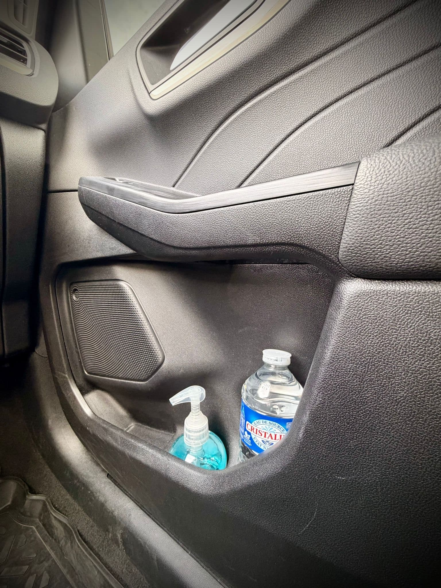 Portière du taxi Ozel avec bouteille d'eau et gel désinfectant accessibles au passager